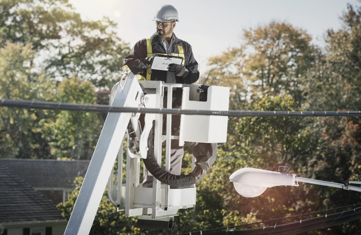 A lineman completing a JSA on a tablet in the field